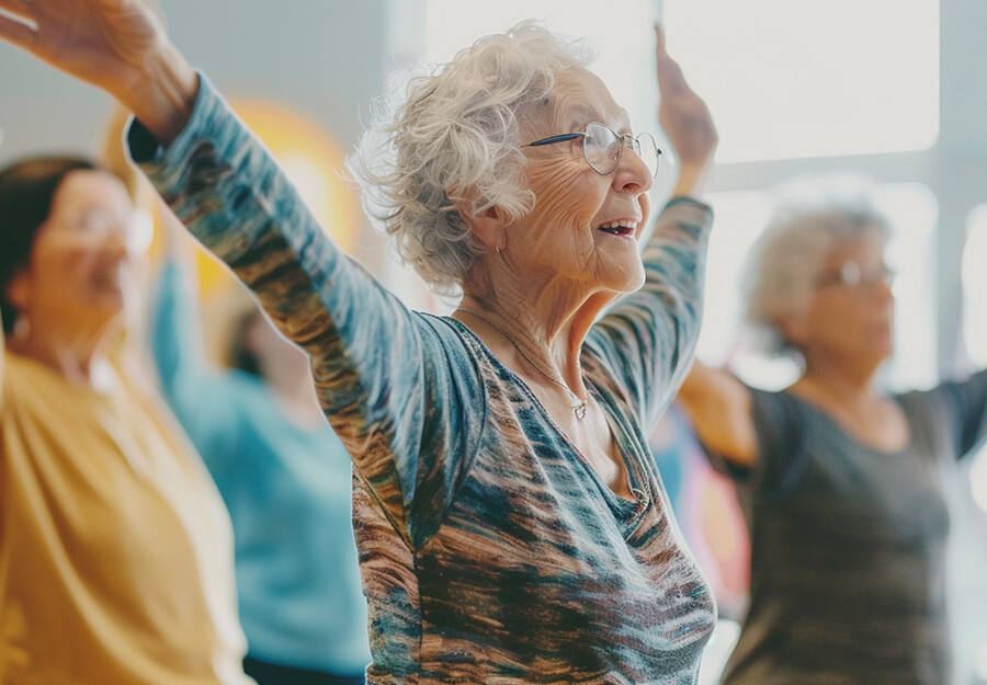 Group of senior women exercising together in a bright room at a senior living community.